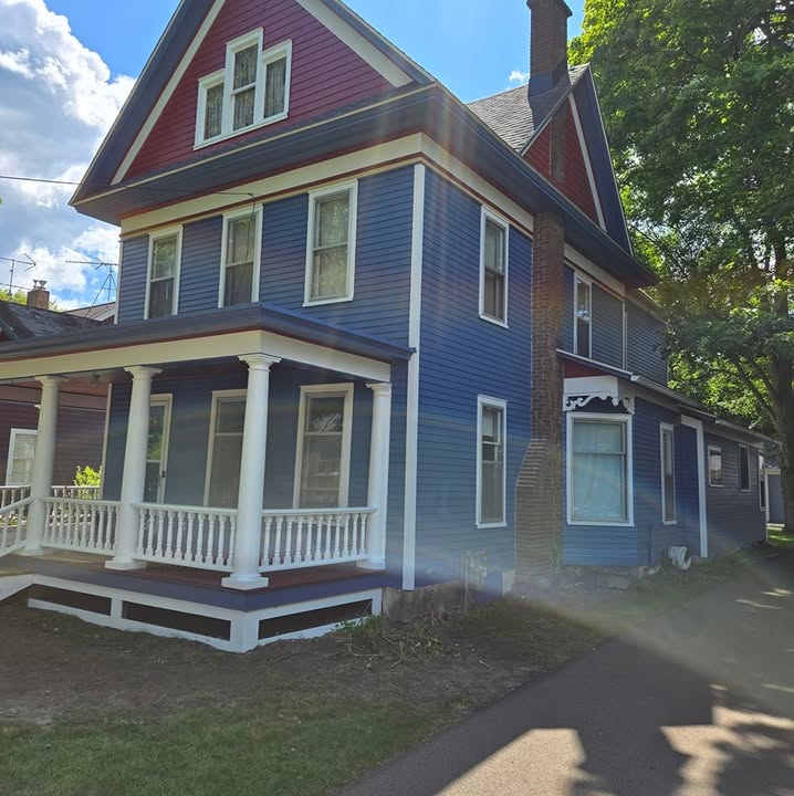 Blue Victorian house with white trim and porch painted by Ron's Painting