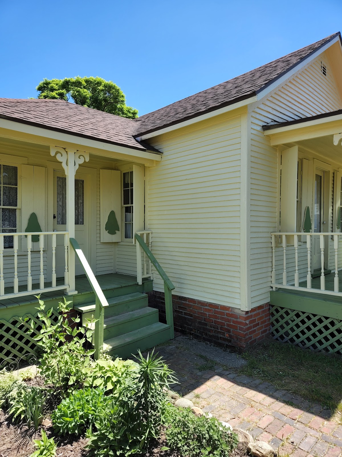 Yellow cottage with freshly painted green porch steps and trim