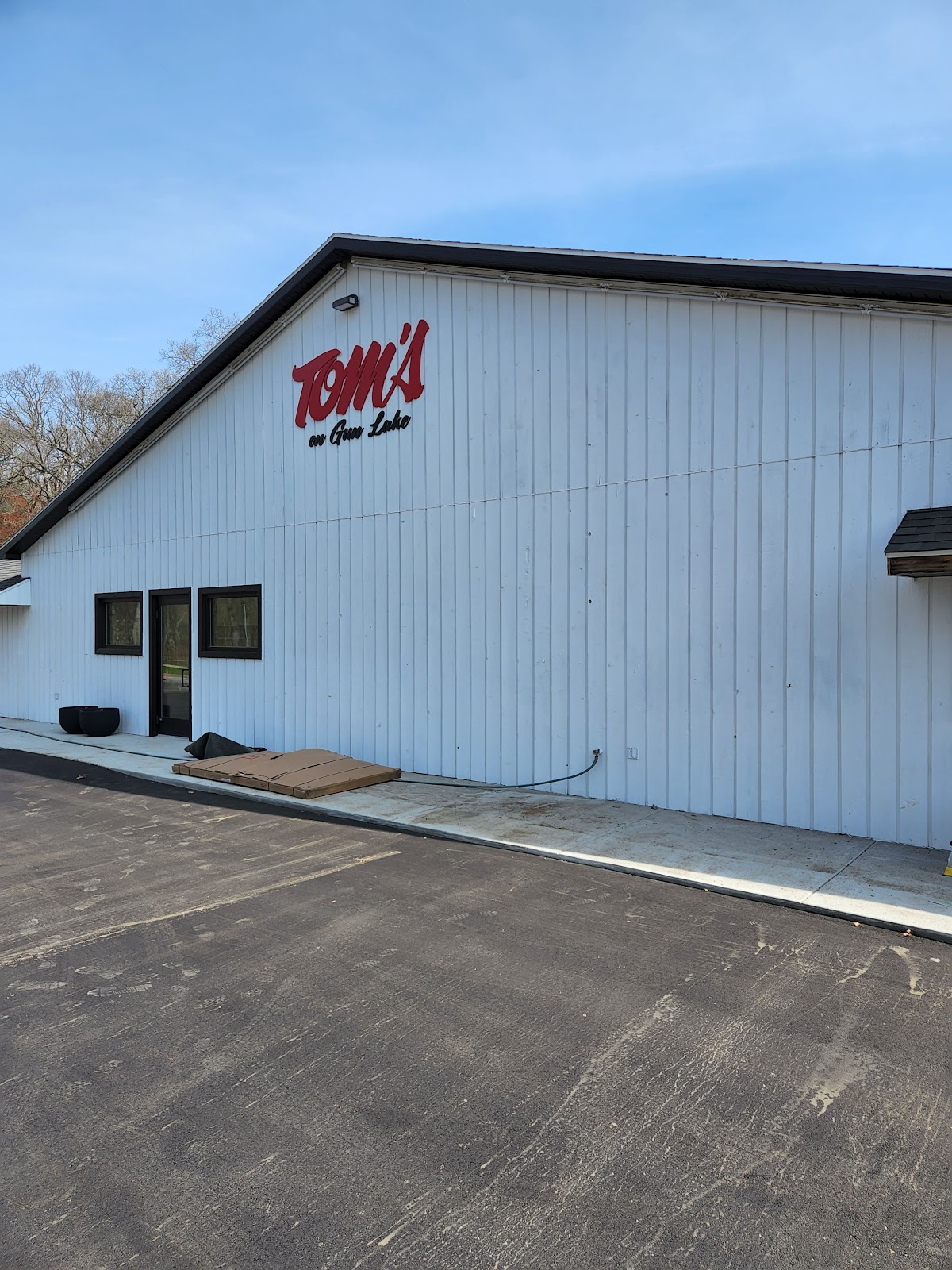 Tom's on Gun Lake commercial building with white siding