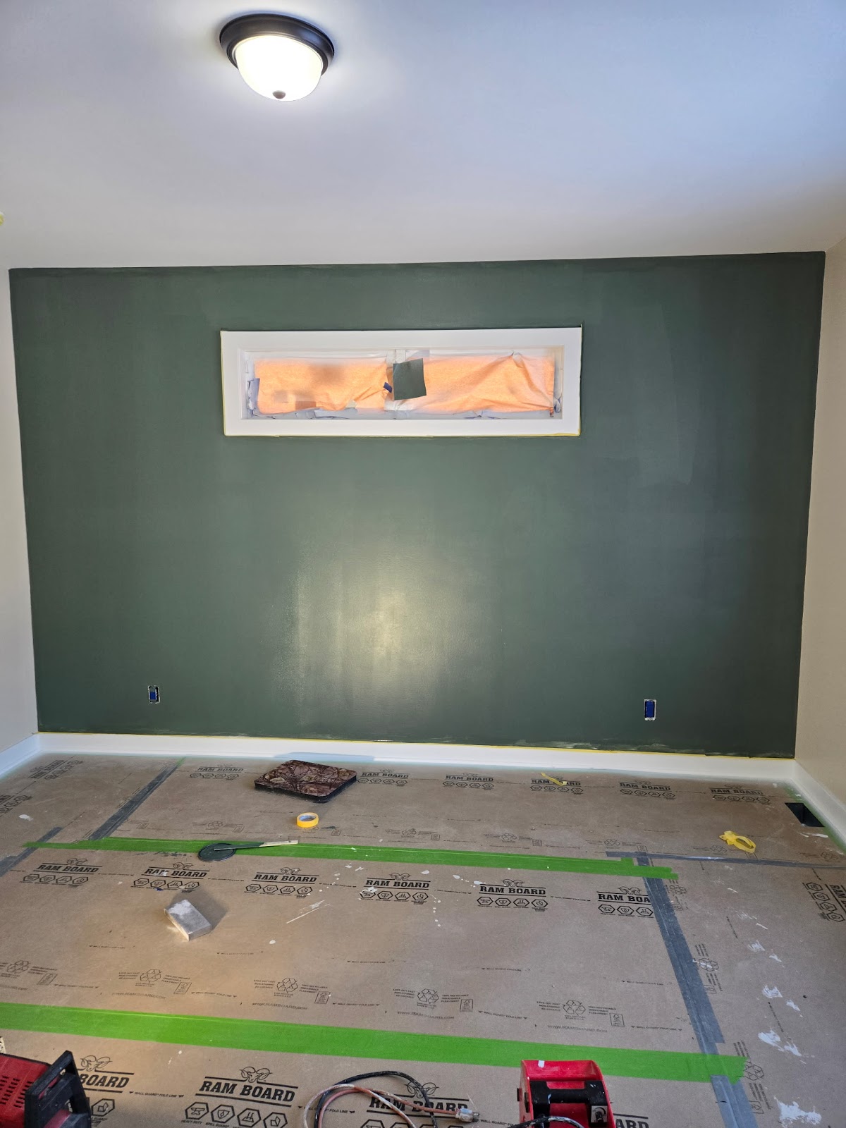 Interior room with a dark green accent wall and masked floor