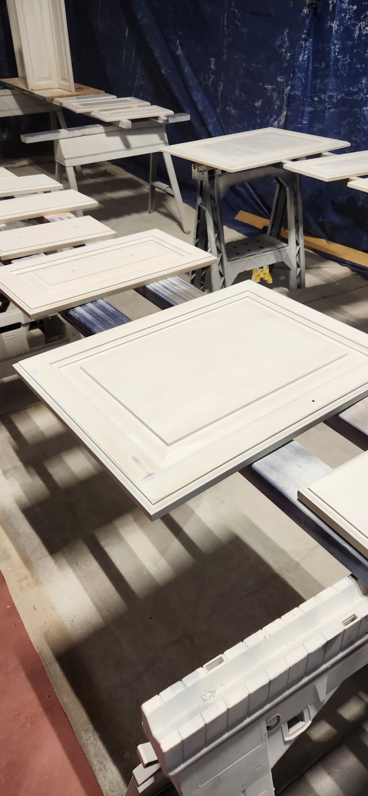 Cabinet doors drying on racks after finishing